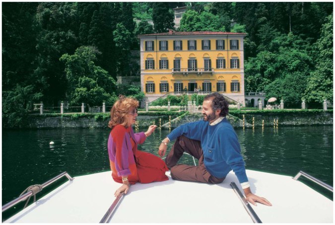 Fashion designer Gianni Versace, along with Lalla Spagnol, on a boat in front of his seventeenth-century Villa Fontanelle